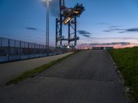 a sky lift sitting in the middle of a bridge at dusk with light shining from it