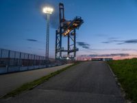 a sky lift sitting in the middle of a bridge at dusk with light shining from it