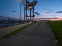 a sky lift sitting in the middle of a bridge at dusk with light shining from it