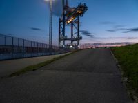 a sky lift sitting in the middle of a bridge at dusk with light shining from it