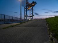 a sky lift sitting in the middle of a bridge at dusk with light shining from it