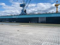 a big blue and white ship in the port of loading cargo on its ship,