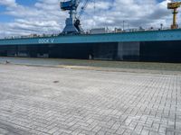 a big blue and white ship in the port of loading cargo on its ship,