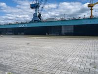 a big blue and white ship in the port of loading cargo on its ship,