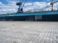 a big blue and white ship in the port of loading cargo on its ship,