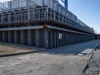 this concrete walkway has a ramp on top of it for access to a large storage area