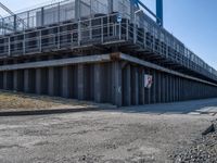 this concrete walkway has a ramp on top of it for access to a large storage area