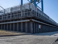 this concrete walkway has a ramp on top of it for access to a large storage area