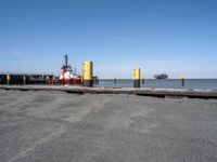 two tugboats docked at the beach in a dock near water and a large ship