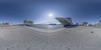 boats sit next to each other on the water in a harbor at night time from a 360 camera