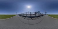 a fisheye view of a person skateboarding down a curved road at the tennis court