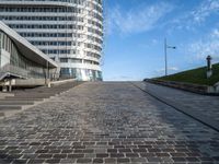 a paved stone walkway in front of a building on an island in the ocean on a sunny day