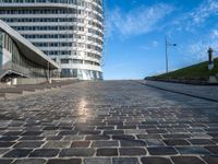 a paved stone walkway in front of a building on an island in the ocean on a sunny day