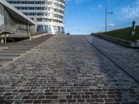 a paved stone walkway in front of a building on an island in the ocean on a sunny day