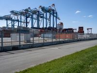 there is a large container ship in the background behind a fenced off area with grass