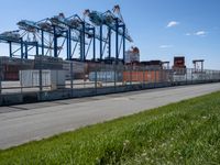 there is a large container ship in the background behind a fenced off area with grass