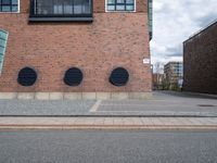 the large brick building has black windows on it's side that allow privacy from the road