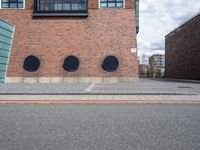 the large brick building has black windows on it's side that allow privacy from the road