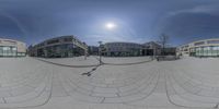 a 360 - ray photograph shows three buildings at different angles and a sidewalk with some people