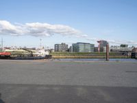 a large body of water with a building in the background, and another bridge crossing the street