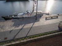 a small ship on the water with flags flying above it as seen from the air