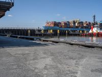 a boat is docked in the water near a dock and dockside with many containers on it