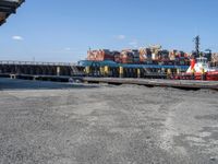 a boat is docked in the water near a dock and dockside with many containers on it