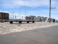 a wooden bench and the harbor, in a small city area with sailboats and boats