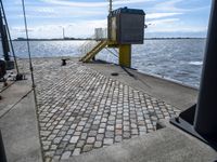 the pier area at a ferry dock with water and a stair on it in front of the water