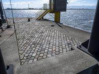 the pier area at a ferry dock with water and a stair on it in front of the water