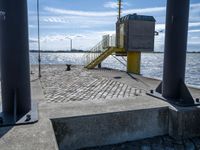 the pier area at a ferry dock with water and a stair on it in front of the water