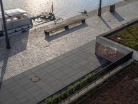 several benches and a boat are sitting on a lake shore with water behind them at the docks