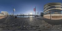 a 360 - view shows a building and water way, and some flags are flying near