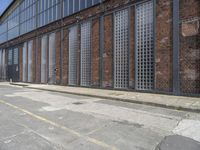 a side alley with brick walls, windows and parking lot at a business district with people walking in