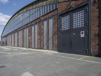 a side alley with brick walls, windows and parking lot at a business district with people walking in