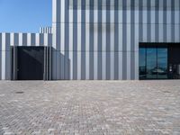 an image of a building that is made with brick stones and glass doors to an industrial area