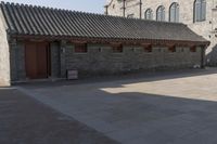 a brick building with an attached roof and a door that reads chinese language written below