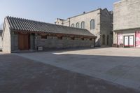 a brick building with an attached roof and a door that reads chinese language written below