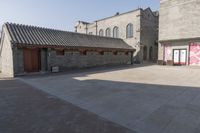 a brick building with an attached roof and a door that reads chinese language written below