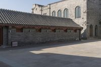 a brick building with an attached roof and a door that reads chinese language written below
