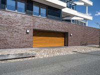 a red fire hydrant in front of a brick building with orange garage doors in front