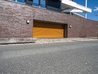 a red fire hydrant in front of a brick building with orange garage doors in front