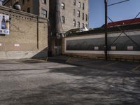 two empty parking spaces near the side of a brick building on a city street that has yellow tape