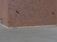 the outside of a brick building on an empty lot, with a red fire hydrant