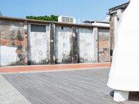 a large piece of white in a wooden floor next to brick buildings and a long white wall