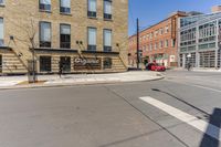 a street with buildings and a sign on the corner, next to a stoplight