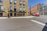 a street with buildings and a sign on the corner, next to a stoplight