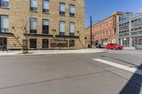 a street with buildings and a sign on the corner, next to a stoplight