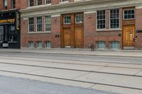 a man crosses the street past a business that is closed down in front of it