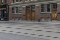 a man crosses the street past a business that is closed down in front of it